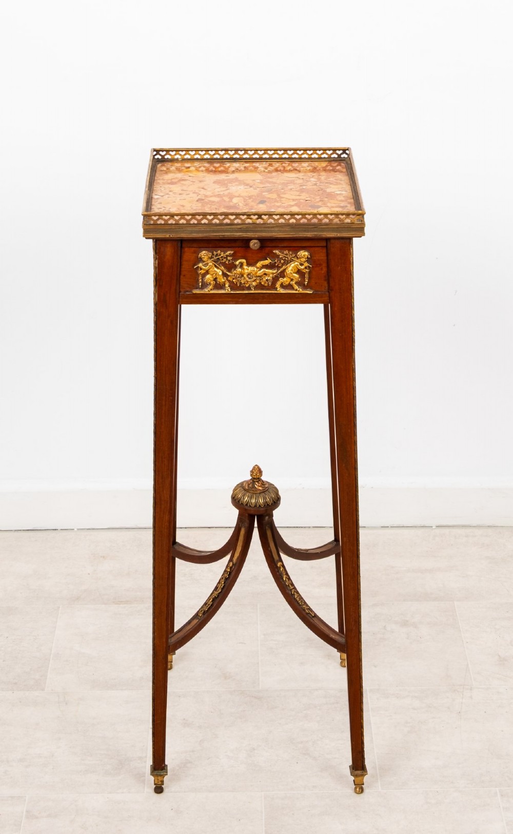 A tall French mahogany side table featuring a square rouge marble top with a pierced brass gallery, gilt-bronze frieze reliefs, and slender tapered legs connected by a curved stretcher. View III