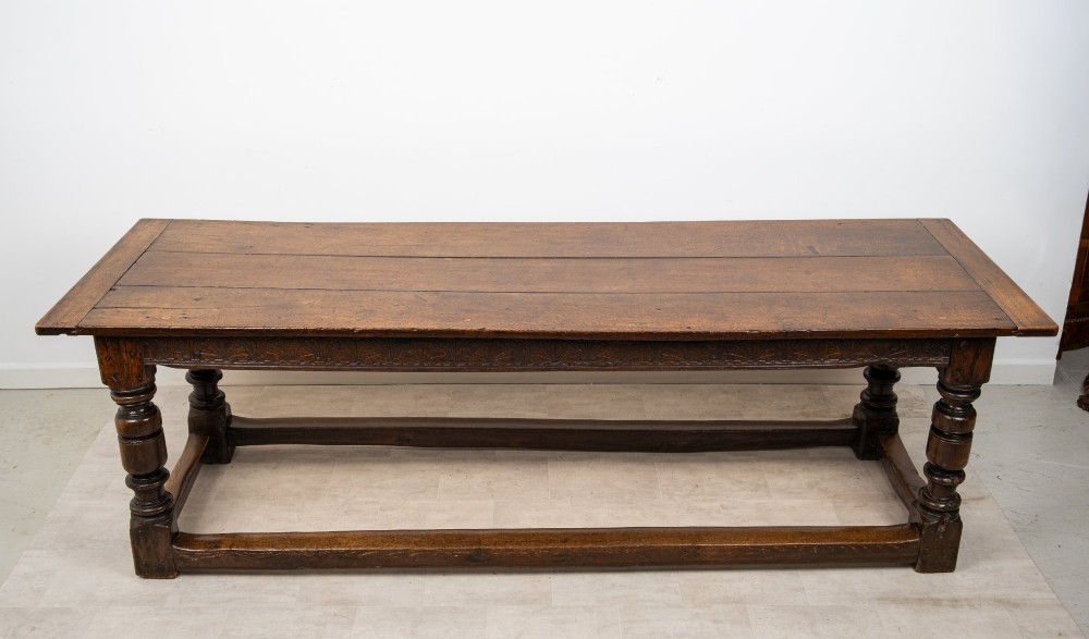 An 18th century carved oak refectory dining table featuring turned legs, a carved frieze apron, and low perimeter stretchers. View IV