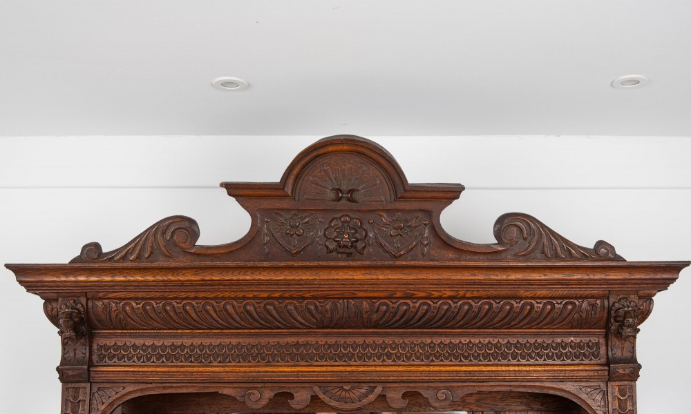 A late Victorian dark carved oak mirror-back sideboard featuring carved figural columns, relief panels, and a upper display shelf. View VII