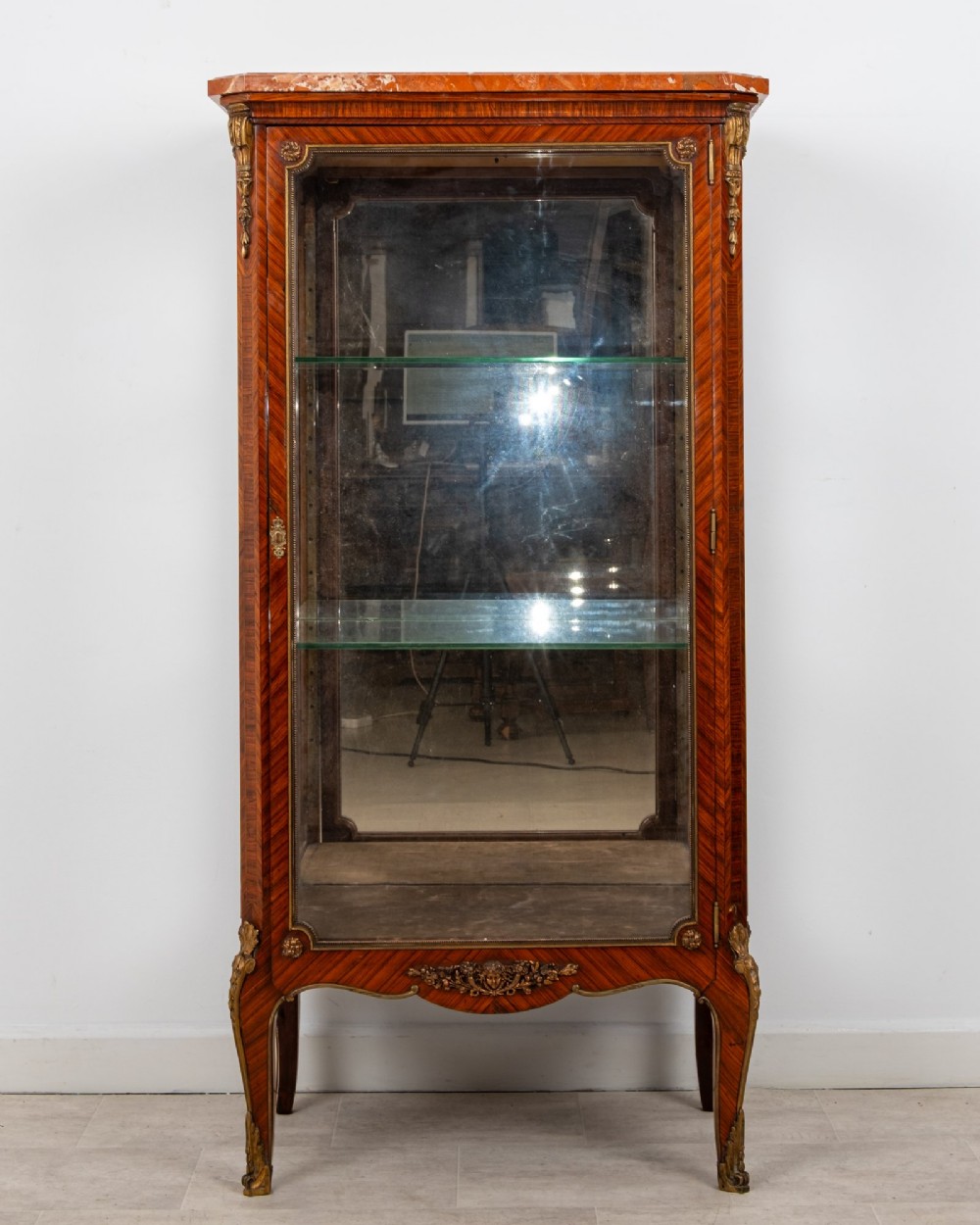 An antique French Louis XV style kingwood vitrine cabinet featuring a single glazed door, gilt-bronze mounts, a mirrored back interior, glass shelves, and a marble top. View II