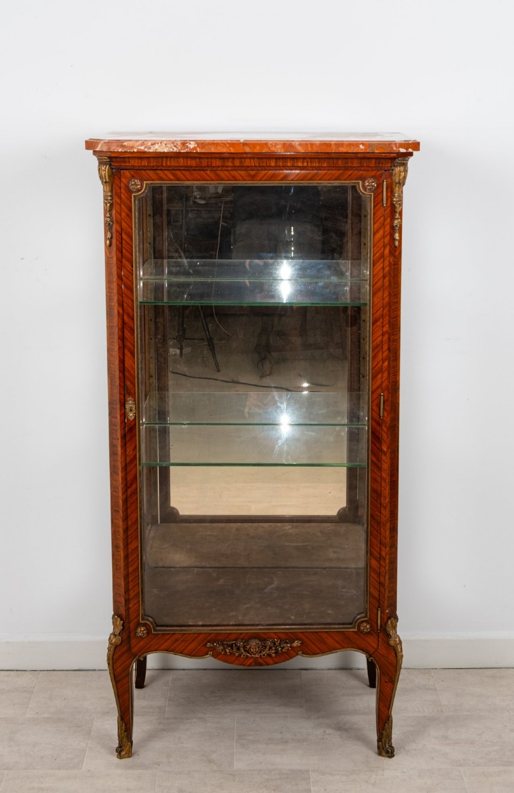 An antique French Louis XV style kingwood vitrine cabinet featuring a single glazed door, gilt-bronze mounts, a mirrored back interior, glass shelves, and a marble top. View III