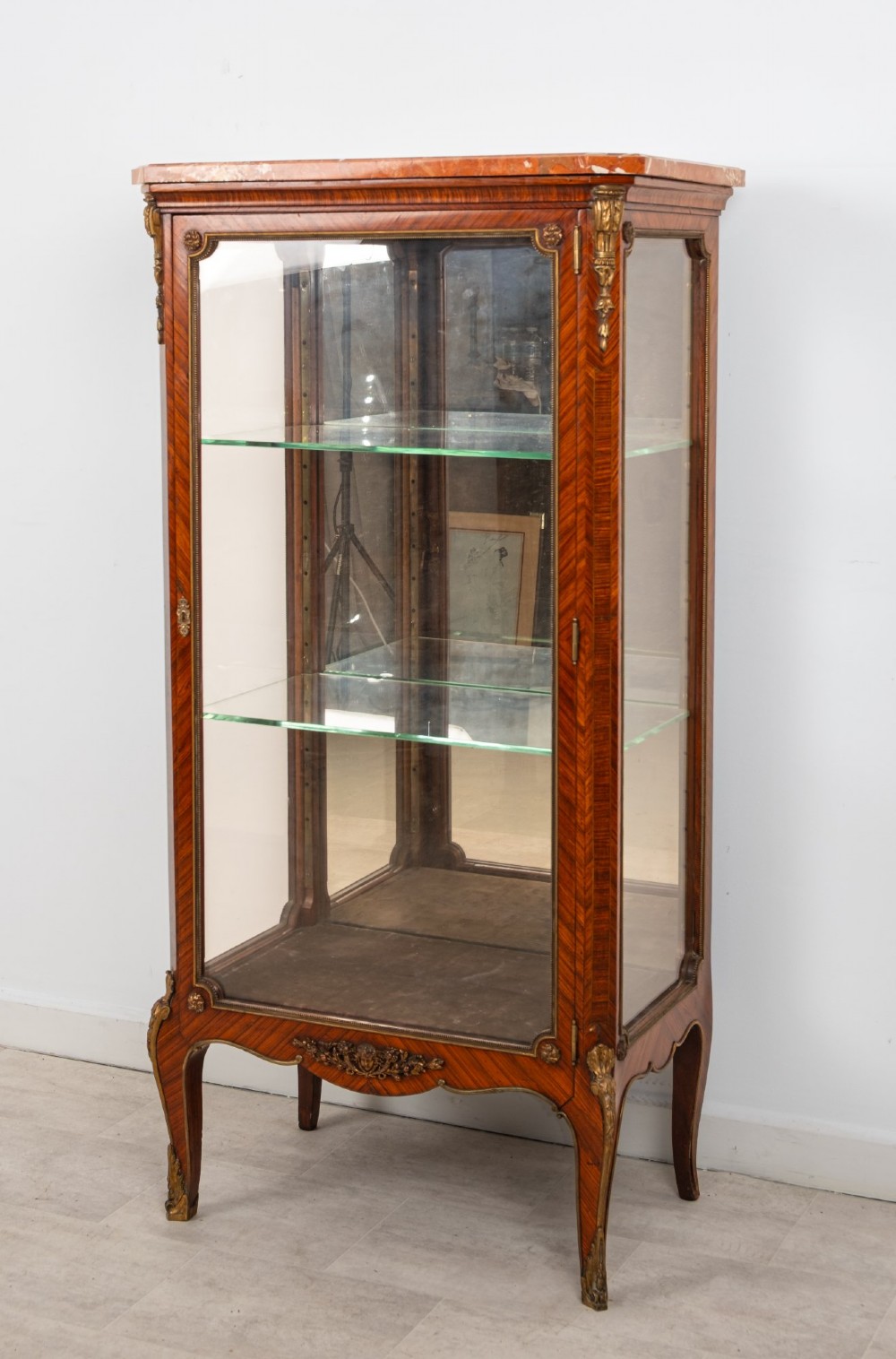 An antique French Louis XV style kingwood vitrine cabinet featuring a single glazed door, gilt-bronze mounts, a mirrored back interior, glass shelves, and a marble top. View IV