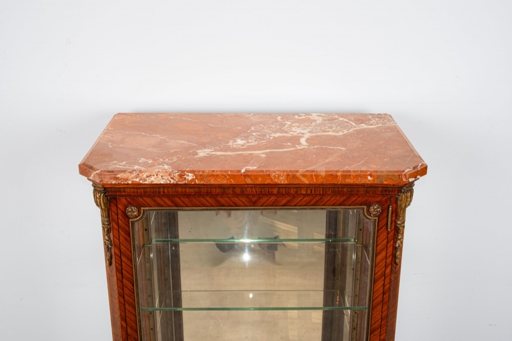 An antique French Louis XV style kingwood vitrine cabinet featuring a single glazed door, gilt-bronze mounts, a mirrored back interior, glass shelves, and a marble top. View VII