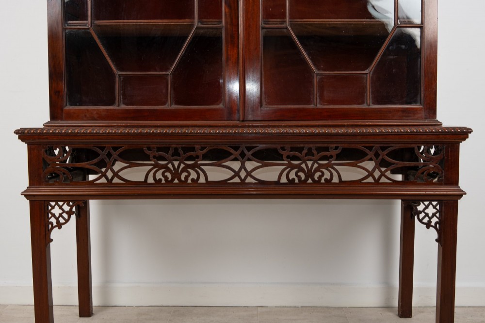 An antique mahogany astragal glazed bookcase resting on a carved matching stand with fretwork detailing. View IV