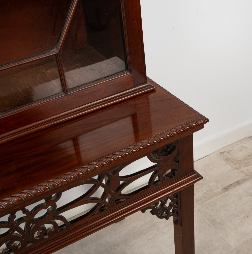 An antique mahogany astragal glazed bookcase resting on a carved matching stand with fretwork detailing. View VII