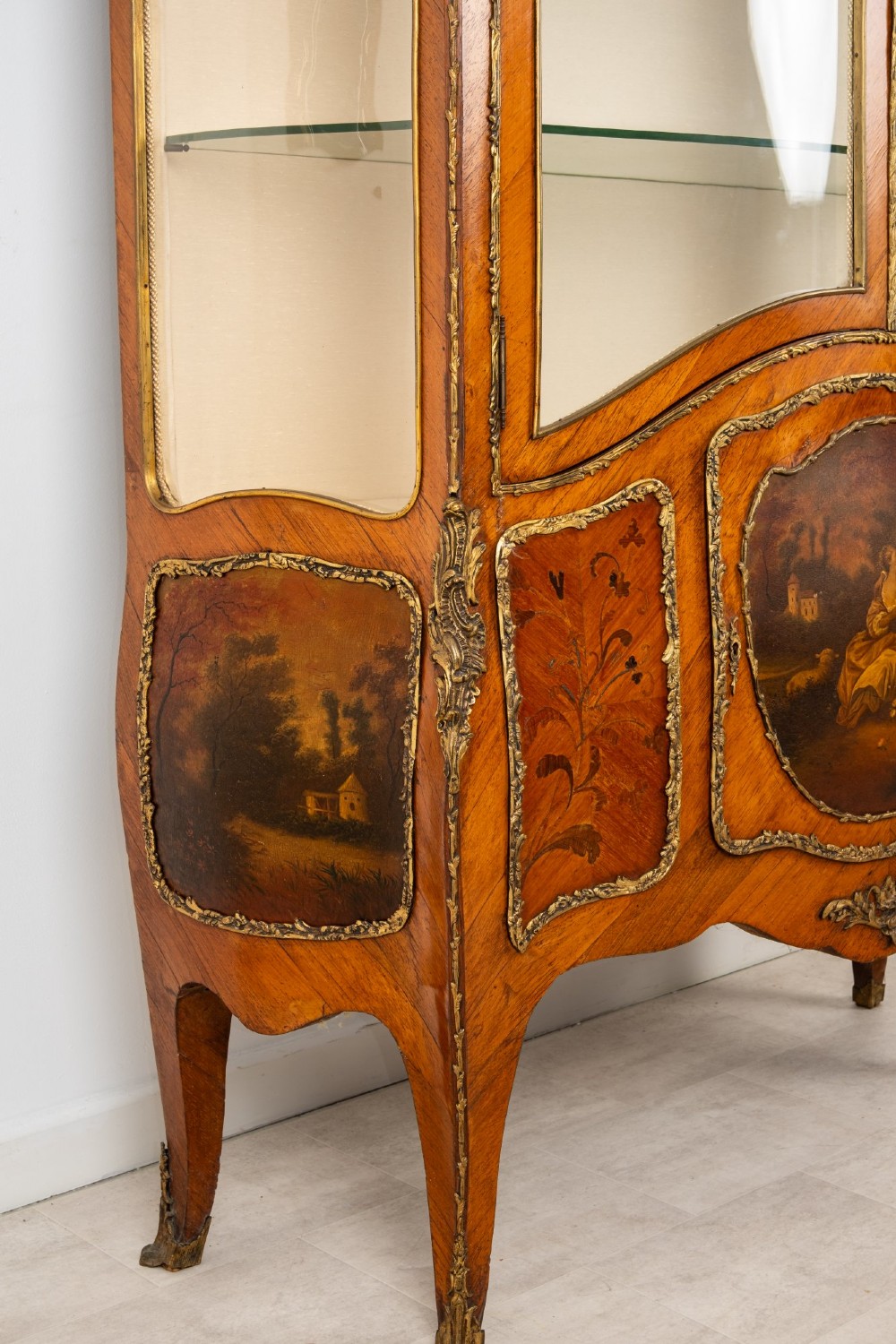 An antique French Louis XV style kingwood vitrine cabinet featuring glass doors, gilded ormolu mounts, and a hand-painted Vernis Martin panel at the base. View V