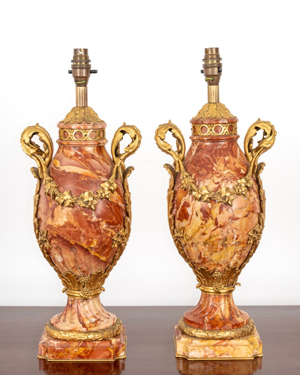 A pair of late nineteenth-century French urn-form table lamps crafted from veined red marble with gilt bronze scroll handles and floral garlands. View III