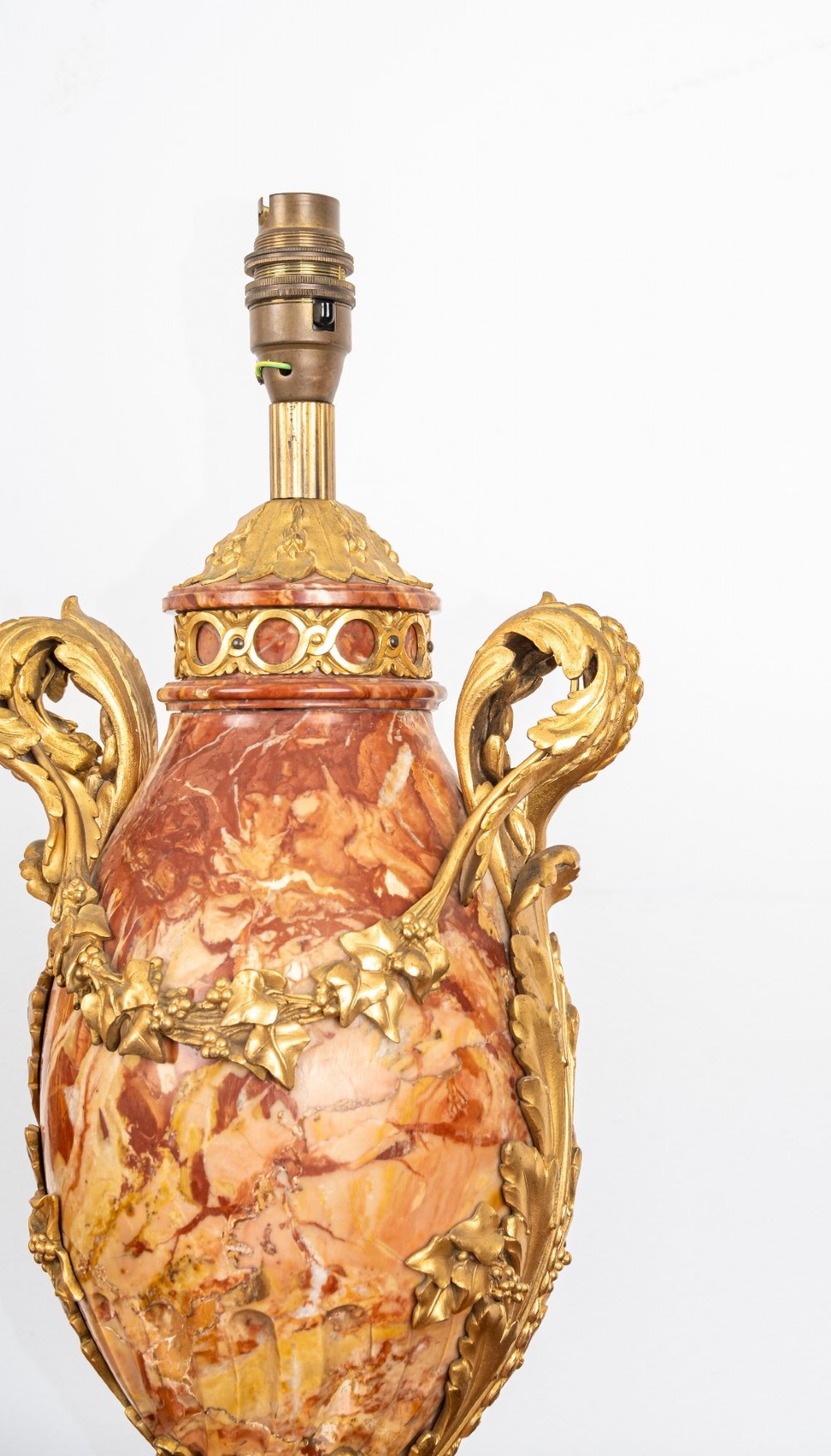 A pair of late nineteenth-century French urn-form table lamps crafted from veined red marble with gilt bronze scroll handles and floral garlands. View V