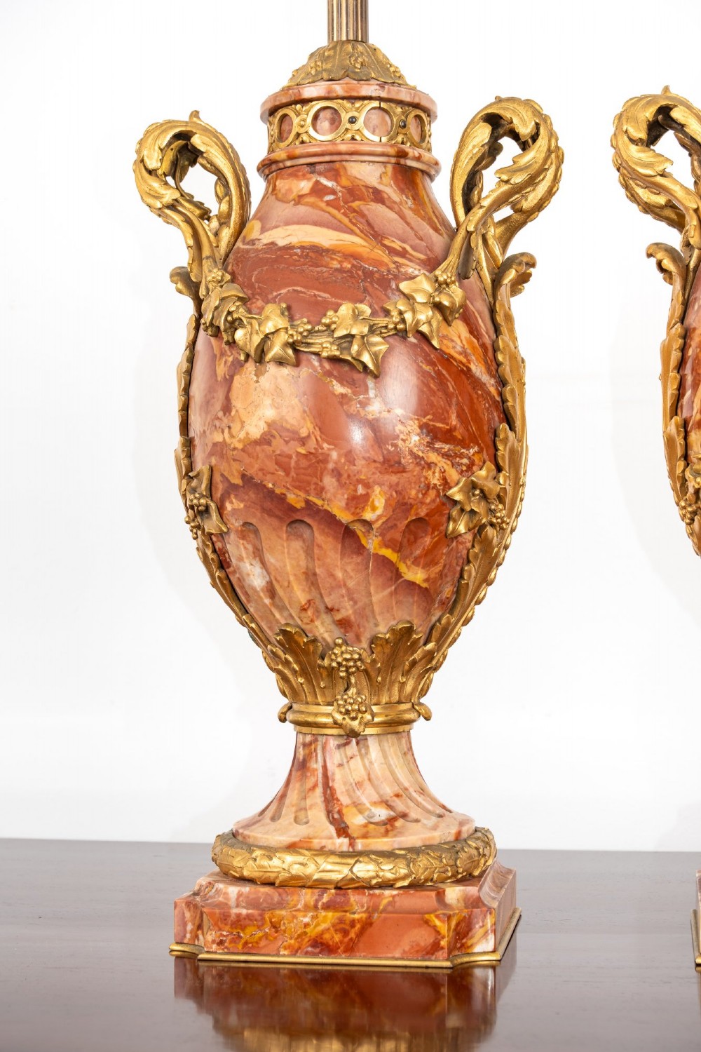 A pair of late nineteenth-century French urn-form table lamps crafted from veined red marble with gilt bronze scroll handles and floral garlands. View IX