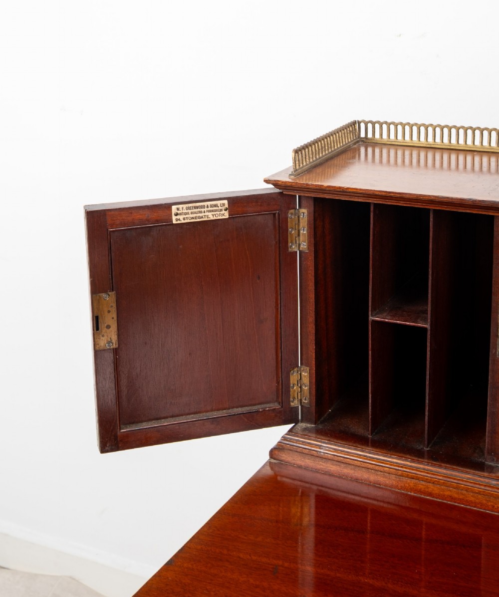 An Edwardian mahogany writing desk featuring floral hand-painted motifs, twin upper cabinets with brass galleries, an arched central mirror, and a single frieze drawer. View IX