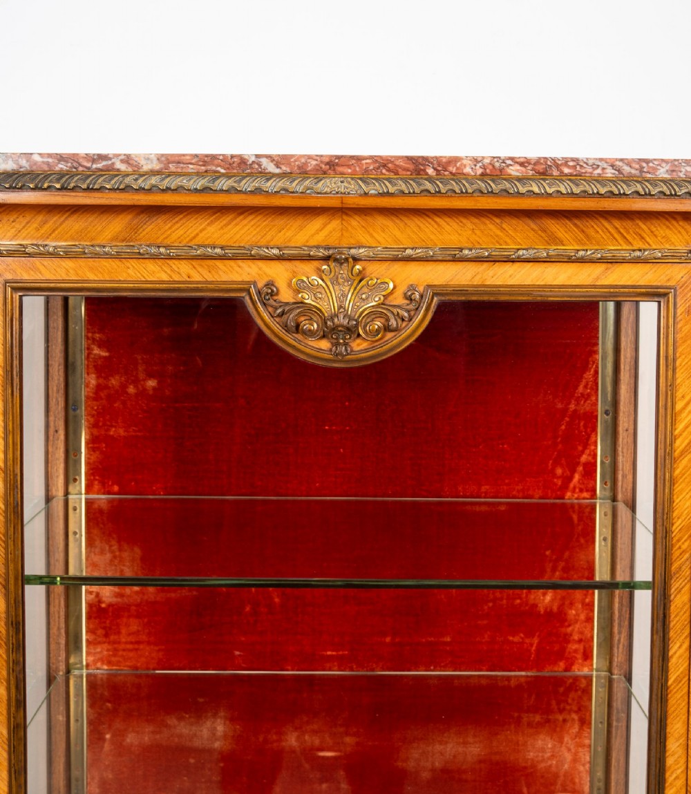 Pair of late 19th-century French kingwood vitrine cabinets featuring marble tops, glass display sections, hand-painted lower panels, and decorative gilt bronze mounts. View V