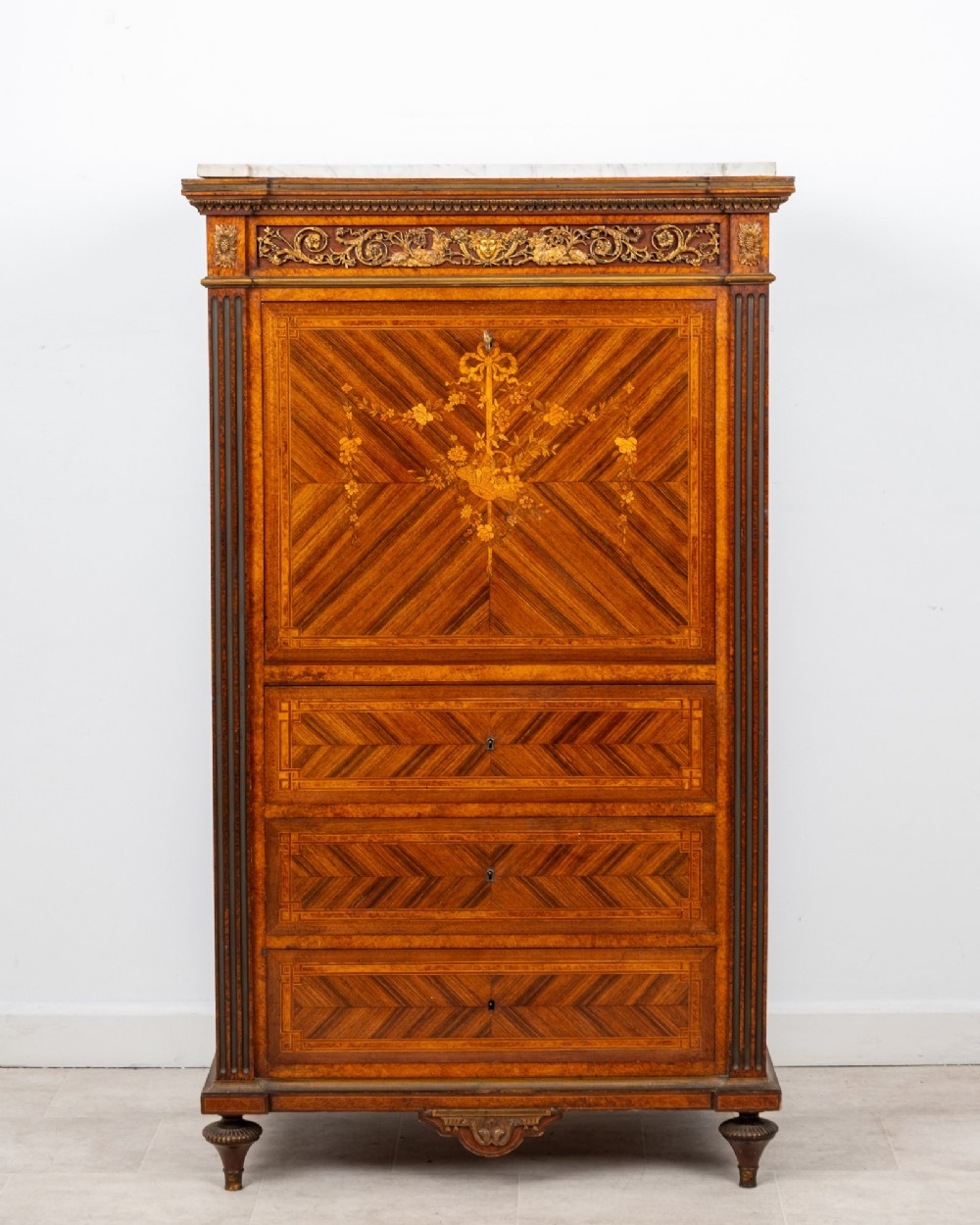 An antique nineteenth-century French parquetry secretaire a abattant writing desk featuring geometric veneer patterns, floral marquetry, gilt bronze mounts, and a marble top. View II