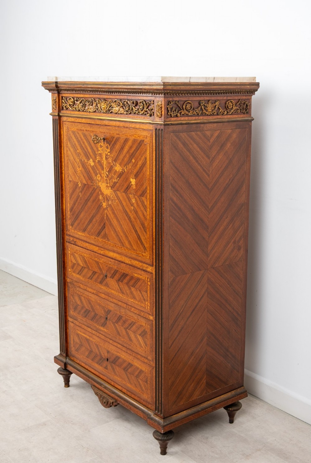 An antique nineteenth-century French parquetry secretaire a abattant writing desk featuring geometric veneer patterns, floral marquetry, gilt bronze mounts, and a marble top. View VII