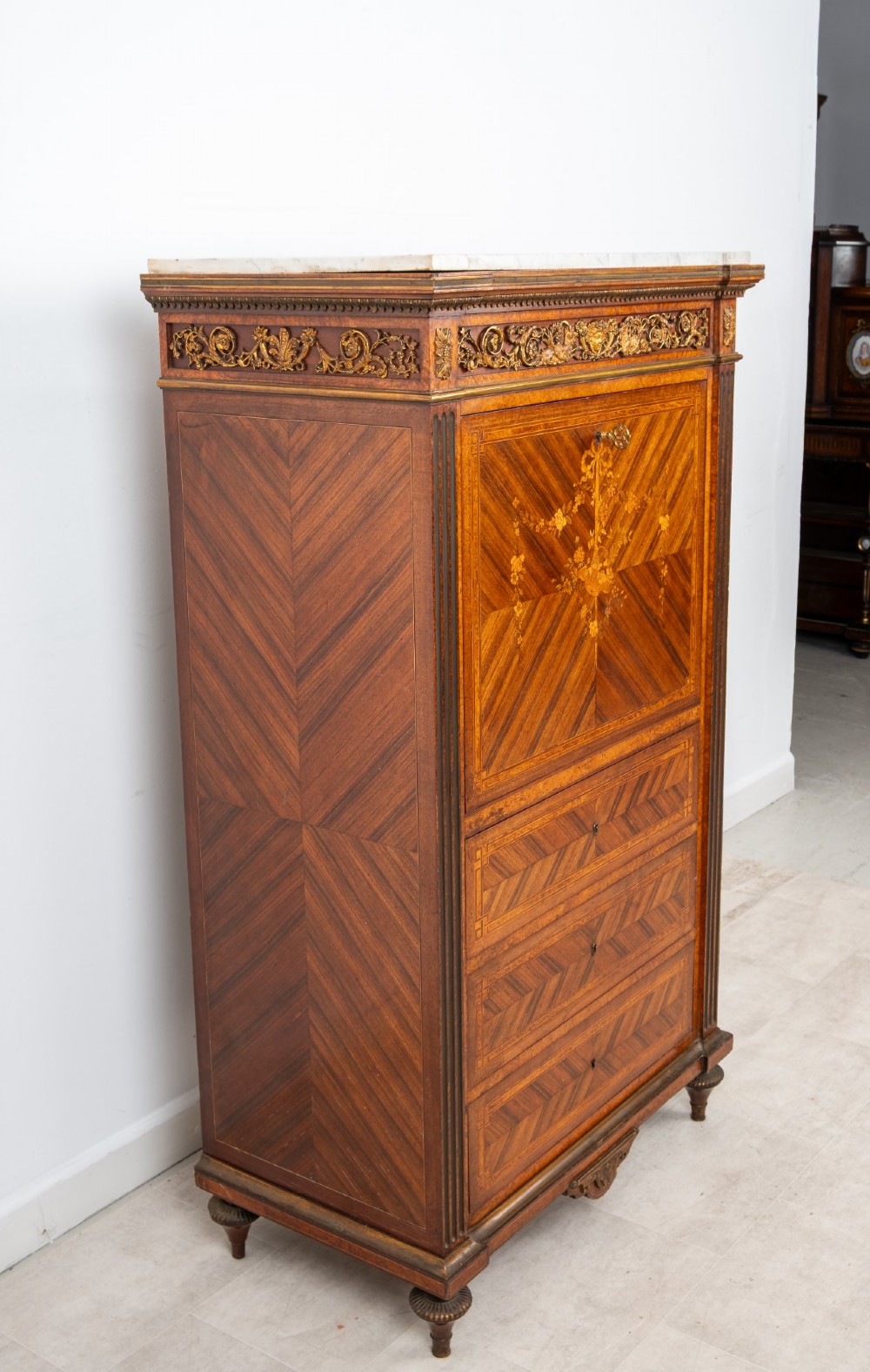An antique nineteenth-century French parquetry secretaire a abattant writing desk featuring geometric veneer patterns, floral marquetry, gilt bronze mounts, and a marble top. View VIII