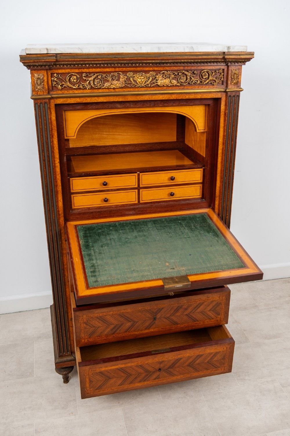 An antique nineteenth-century French parquetry secretaire a abattant writing desk featuring geometric veneer patterns, floral marquetry, gilt bronze mounts, and a marble top. View X