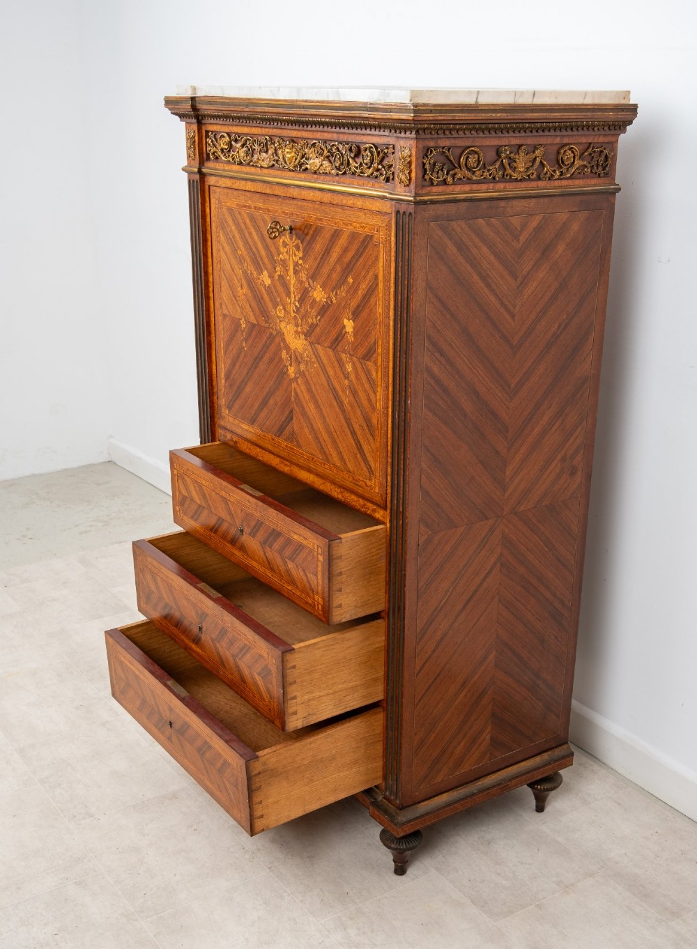 An antique nineteenth-century French parquetry secretaire a abattant writing desk featuring geometric veneer patterns, floral marquetry, gilt bronze mounts, and a marble top. View XI