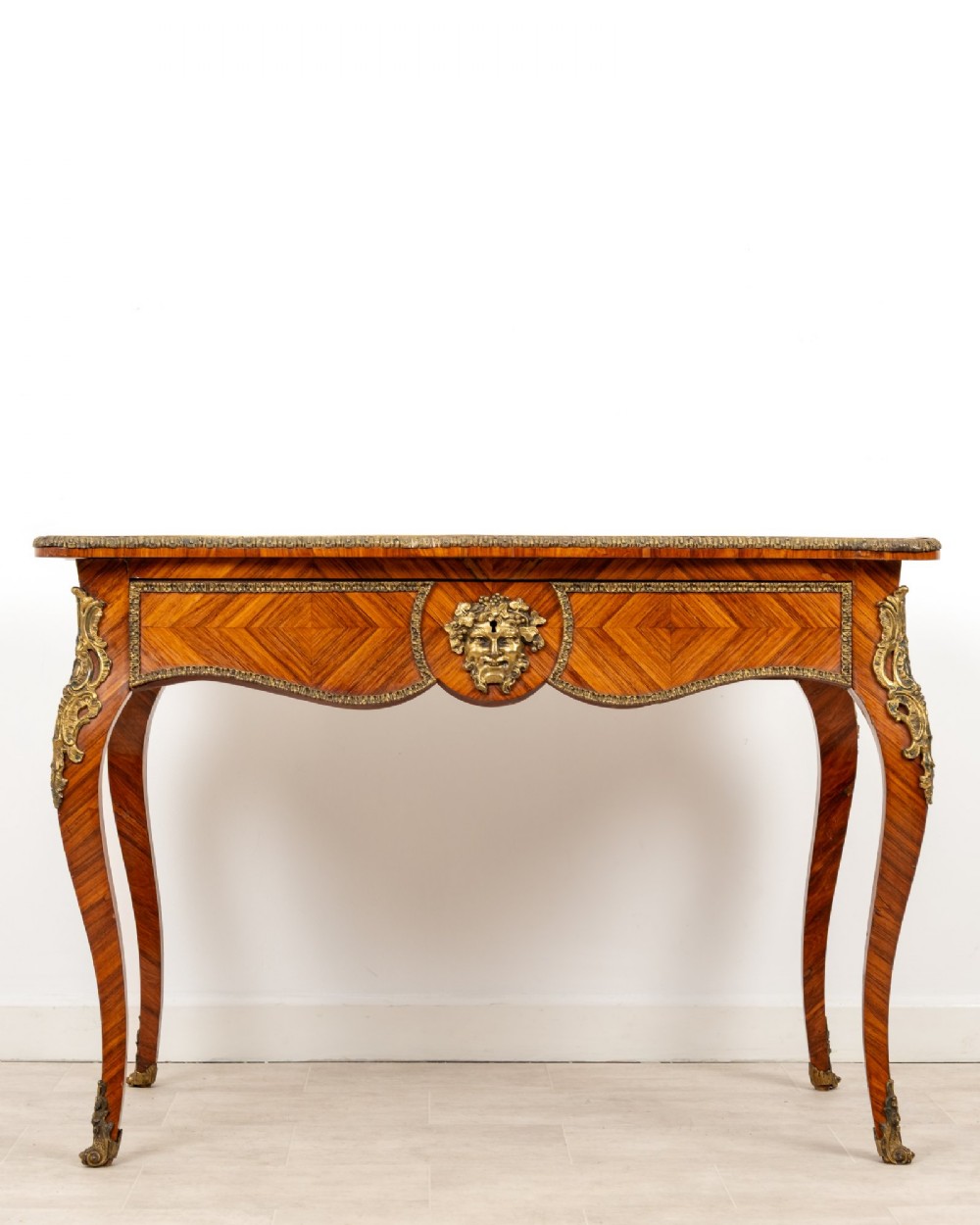 A late 19th-century French kingwood bureau plat featuring a red leather inset top, geometric parquetry veneer, ormolu mounts, and cabriole legs. View II