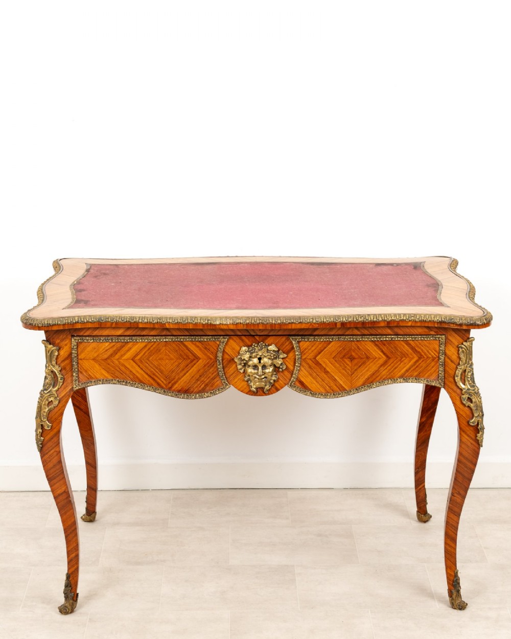 A late 19th-century French kingwood bureau plat featuring a red leather inset top, geometric parquetry veneer, ormolu mounts, and cabriole legs. View III