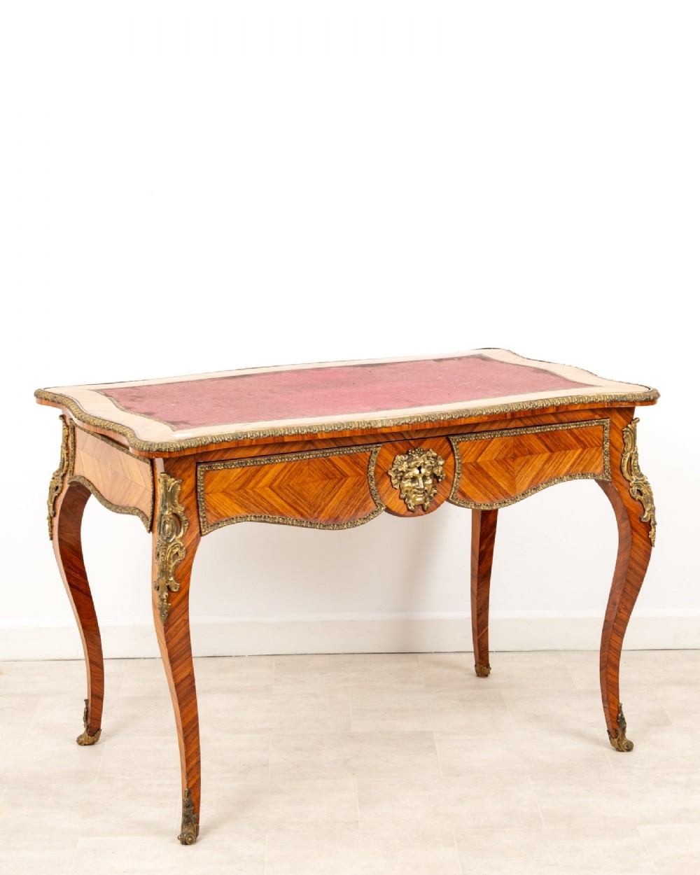 A late 19th-century French kingwood bureau plat featuring a red leather inset top, geometric parquetry veneer, ormolu mounts, and cabriole legs. View IV