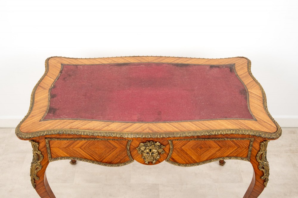 A late 19th-century French kingwood bureau plat featuring a red leather inset top, geometric parquetry veneer, ormolu mounts, and cabriole legs. View VIII