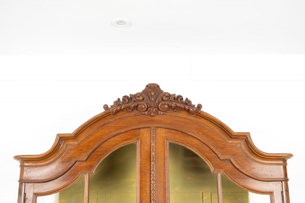 A Queen Anne Revival walnut display cabinet featuring a shaped pediment, double glazed doors, a single lower drawer, and carved cabriole legs. View II