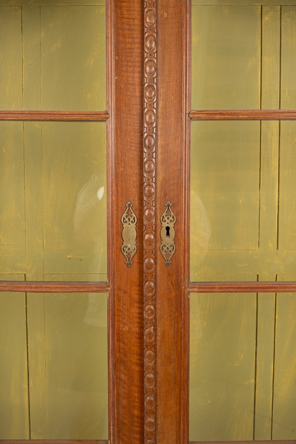 A Queen Anne Revival walnut display cabinet featuring a shaped pediment, double glazed doors, a single lower drawer, and carved cabriole legs. View V