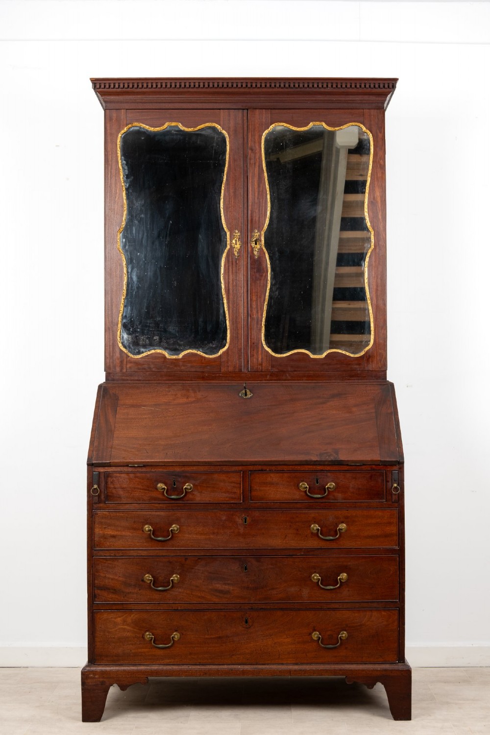 An eighteenth-century mahogany bureau bookcase featuring shaped mirrored double doors on the upper cabinet, a slant-front desk midsection, and four graduated drawers below with brass drop handles. View III