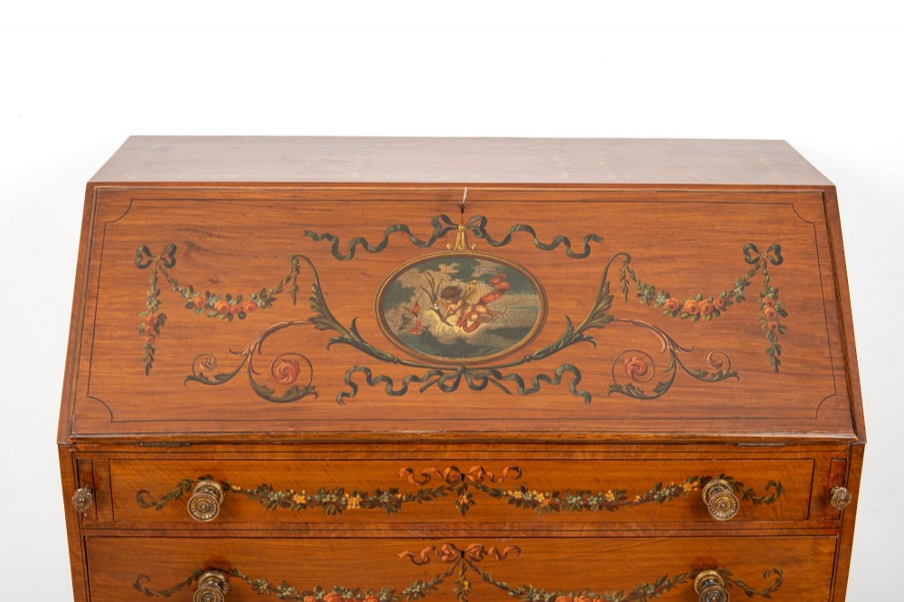 An Edwardian satinwood slant-front bureau with hand-painted floral swags, ribbon garlands, four drawers, and bracket feet. View III