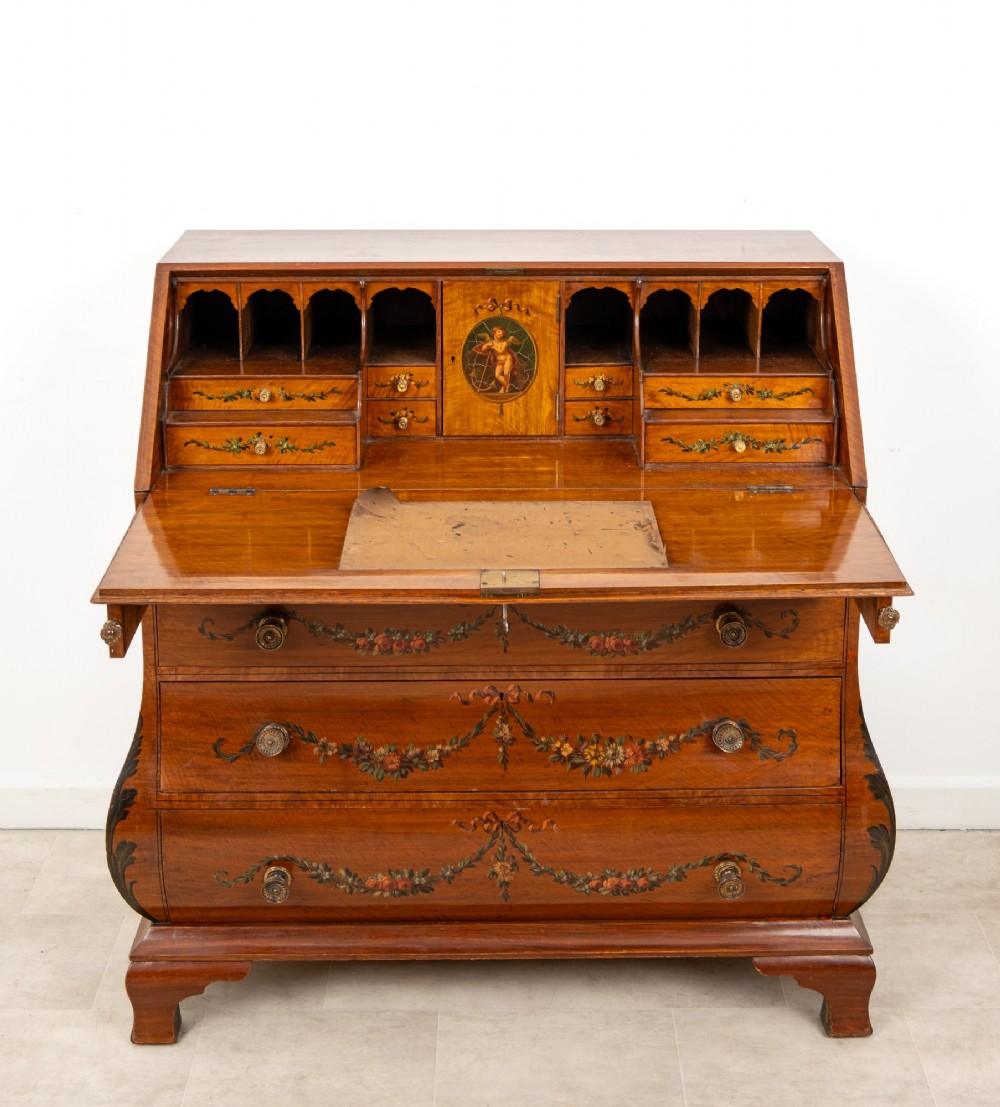 An Edwardian satinwood slant-front bureau with hand-painted floral swags, ribbon garlands, four drawers, and bracket feet. View VIII