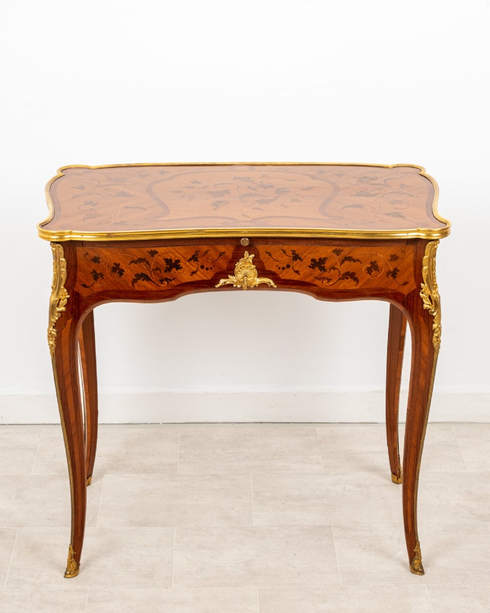 A French Louis XV style kingwood bureau plat featuring floral marquetry inlay, curved cabriole legs, and gilt-bronze mounts. View II