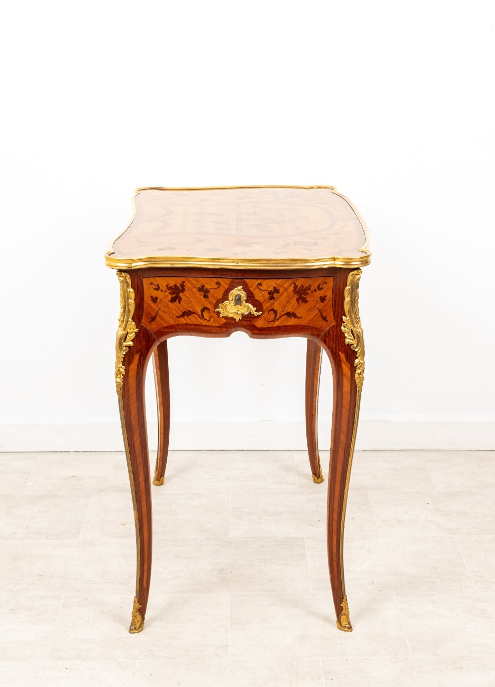 A French Louis XV style kingwood bureau plat featuring floral marquetry inlay, curved cabriole legs, and gilt-bronze mounts. View IX