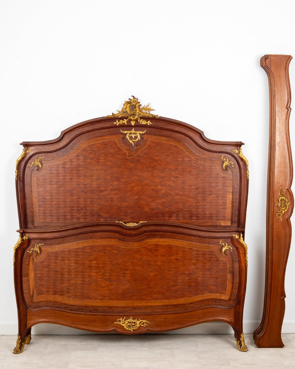 An antique French Louis XV style bedstead crafted from kingwood with geometric parquetry veneers and gilded bronze ormolu mounts. View III