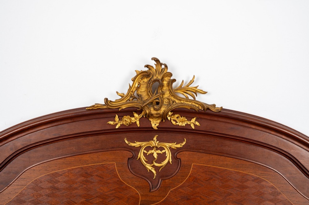 An antique French Louis XV style bedstead crafted from kingwood with geometric parquetry veneers and gilded bronze ormolu mounts. View IV