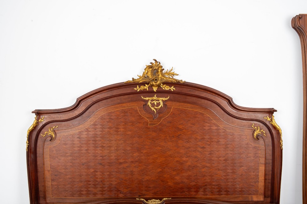 An antique French Louis XV style bedstead crafted from kingwood with geometric parquetry veneers and gilded bronze ormolu mounts. View V