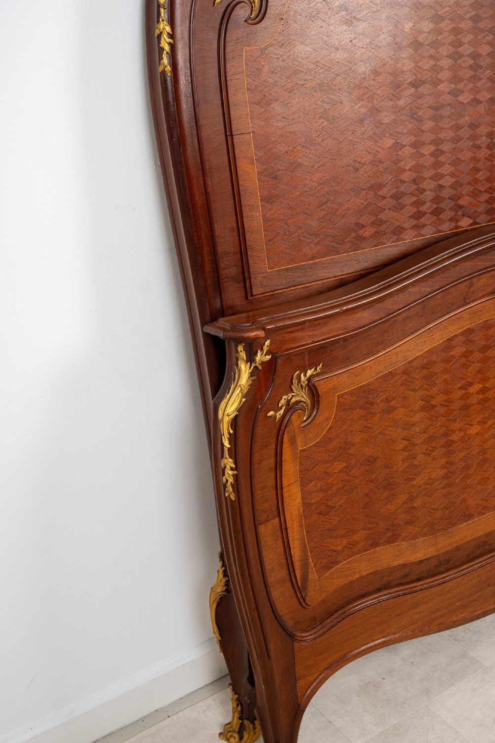 An antique French Louis XV style bedstead crafted from kingwood with geometric parquetry veneers and gilded bronze ormolu mounts. View VI