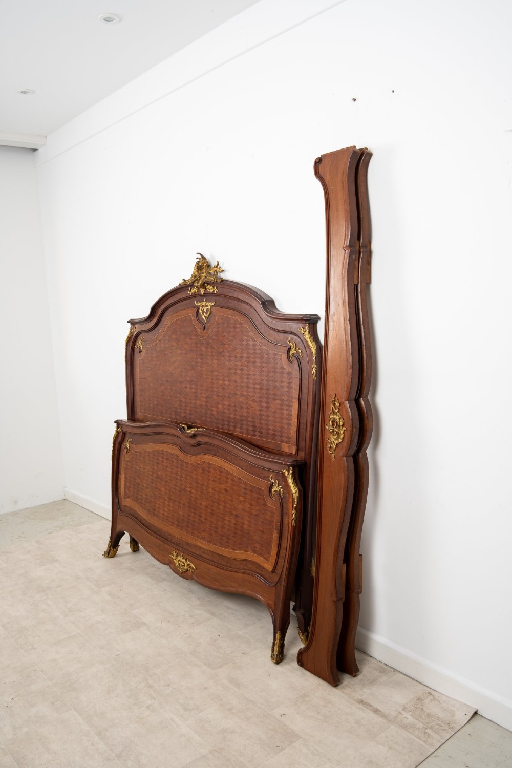 An antique French Louis XV style bedstead crafted from kingwood with geometric parquetry veneers and gilded bronze ormolu mounts. View XI