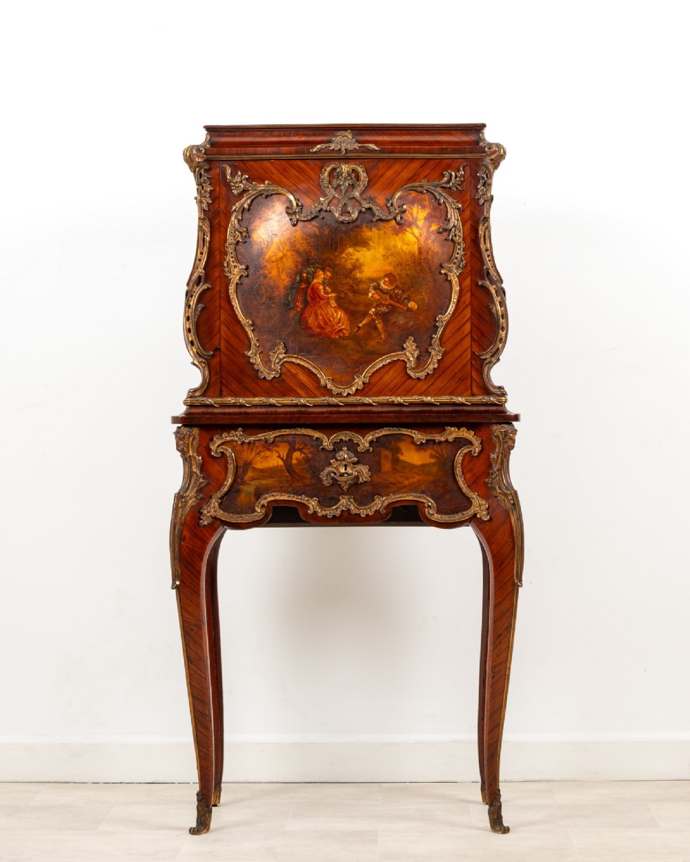 A French Louis XV style kingwood secretaire a abattant on cabriole legs, decorated with gilt bronze mounts and a hand-painted Vernis Martin scene on the fall-front flap.