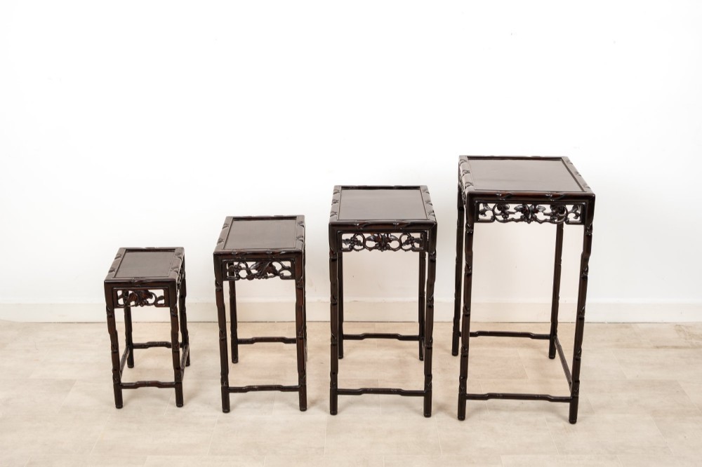 A set of four dark hardwood nested side tables featuring carved faux bamboo legs and openwork carved aprons, shown arranged in a graduated stepped stack. View VIII