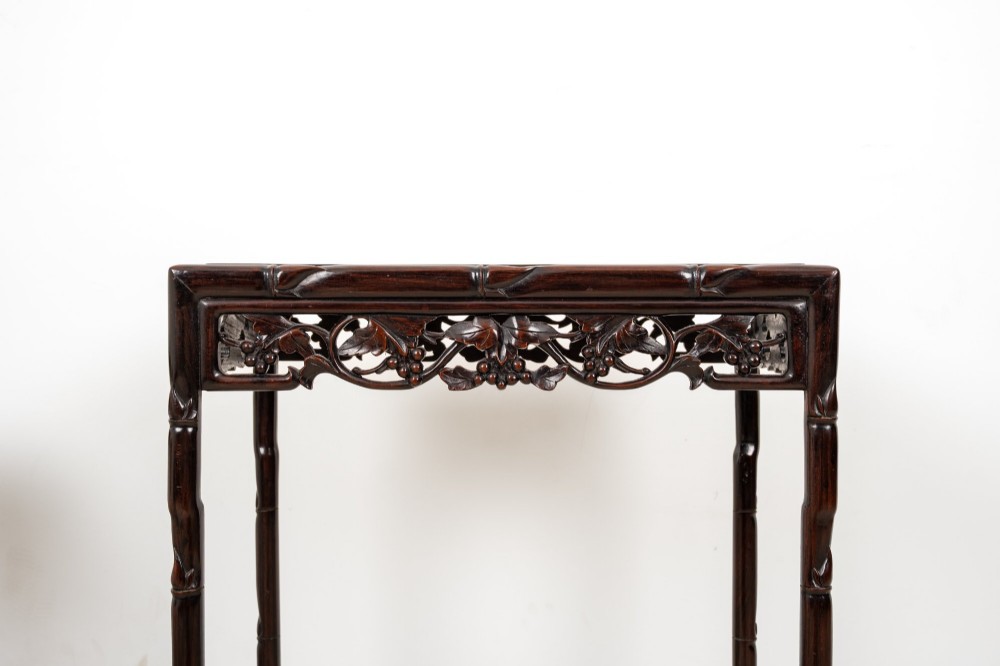 A set of four dark hardwood nested side tables featuring carved faux bamboo legs and openwork carved aprons, shown arranged in a graduated stepped stack. View IX