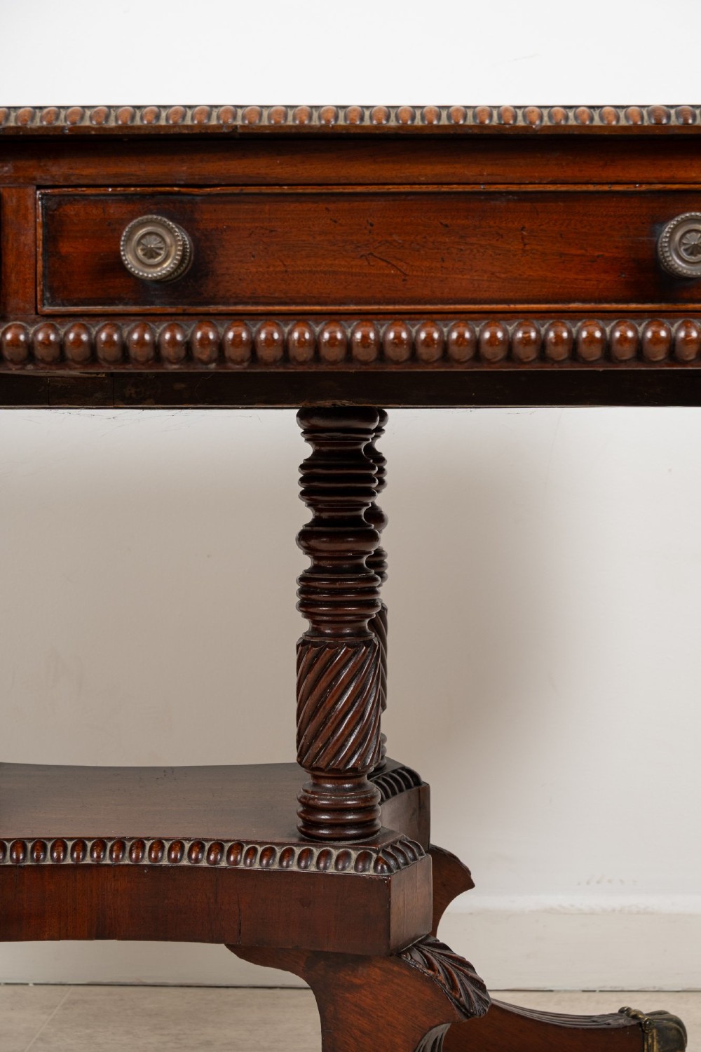 A 19th-century mahogany drop-leaf sofa table with four spiral-turned column supports, frieze drawers, and splayed legs on brass castors. View VI
