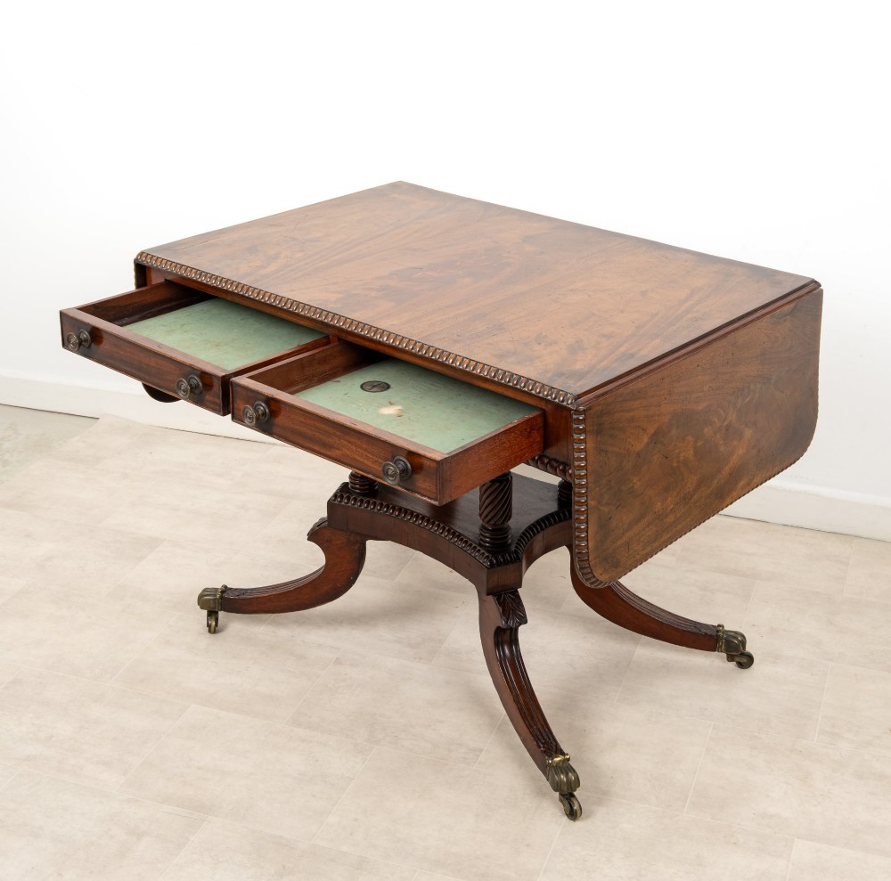 A 19th-century mahogany drop-leaf sofa table with four spiral-turned column supports, frieze drawers, and splayed legs on brass castors. View VII