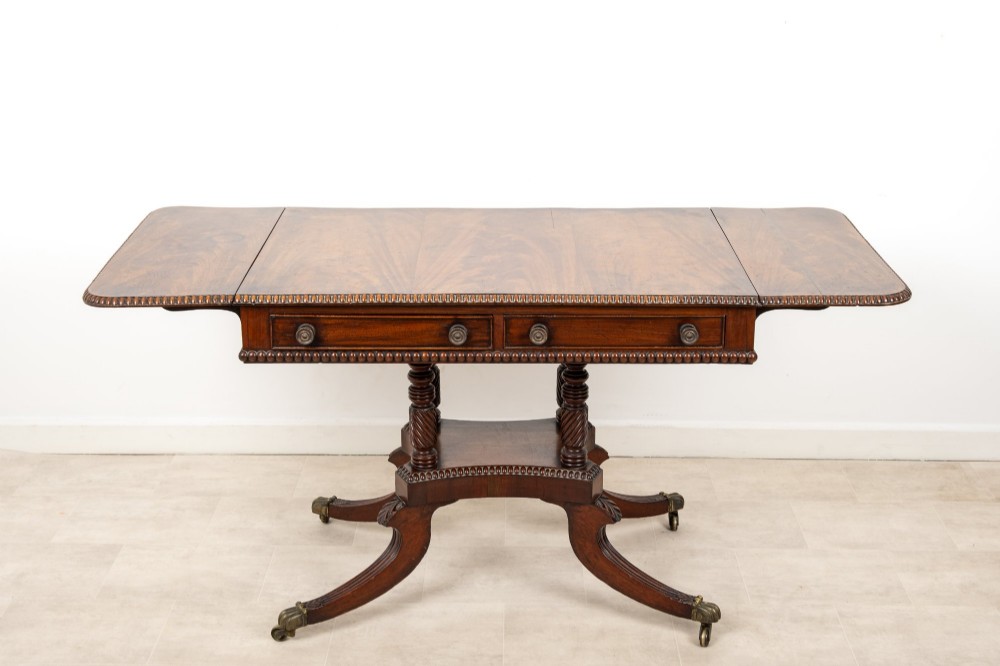 A 19th-century mahogany drop-leaf sofa table with four spiral-turned column supports, frieze drawers, and splayed legs on brass castors. View VIII