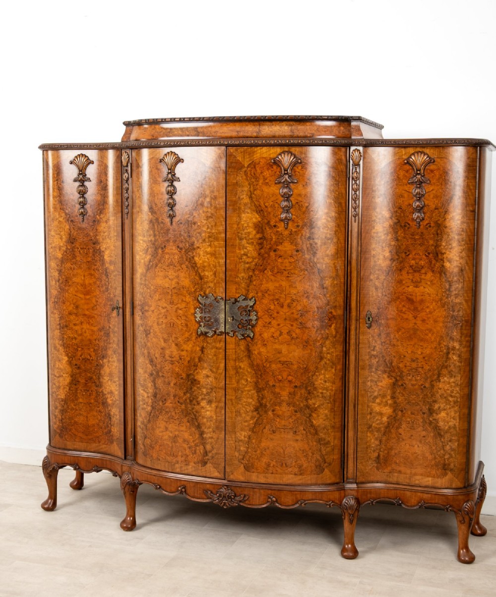 A 1930s burr walnut cocktail cabinet with book-matched veneers, carved shell motifs, brass hinges, and cabriole legs. View III