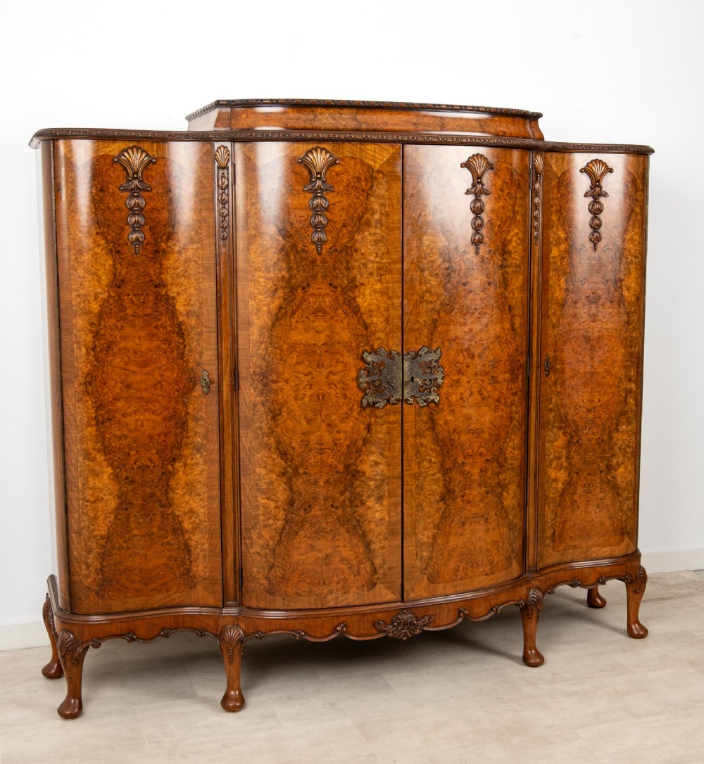 A 1930s burr walnut cocktail cabinet with book-matched veneers, carved shell motifs, brass hinges, and cabriole legs. View IV