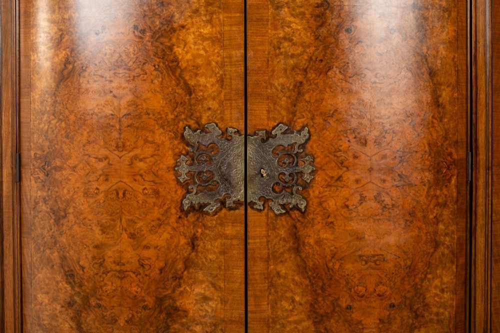 A 1930s burr walnut cocktail cabinet with book-matched veneers, carved shell motifs, brass hinges, and cabriole legs. View VI