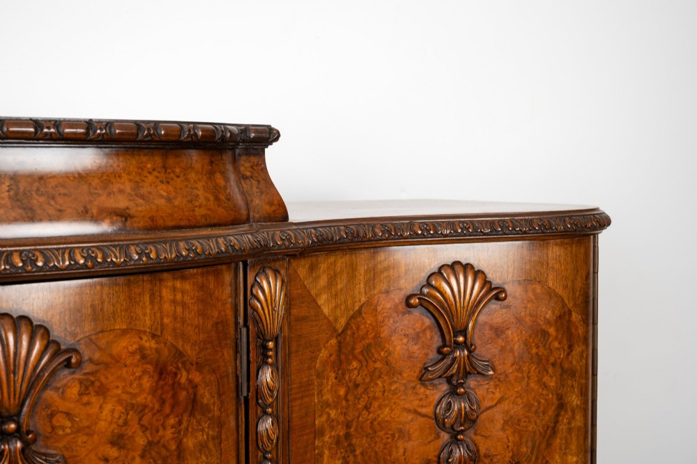 A 1930s burr walnut cocktail cabinet with book-matched veneers, carved shell motifs, brass hinges, and cabriole legs. View VIII
