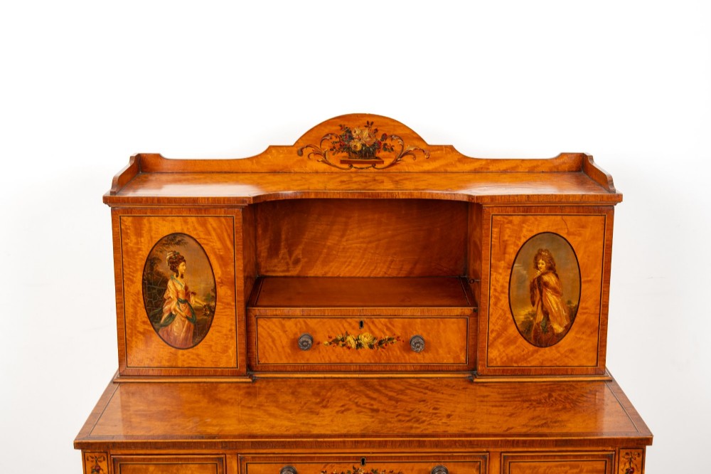 An Edwardian hand-painted satinwood writing desk featuring a raised central cupboard superstructure decorated with painted oval portraits, floral swags, and square tapered legs. View VIII