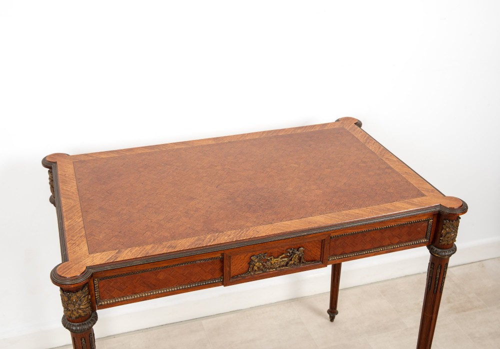 An antique French kingwood writing table featuring geometric parquetry, a single central drawer with ormolu mounts, and four tapered fluted legs. View V
