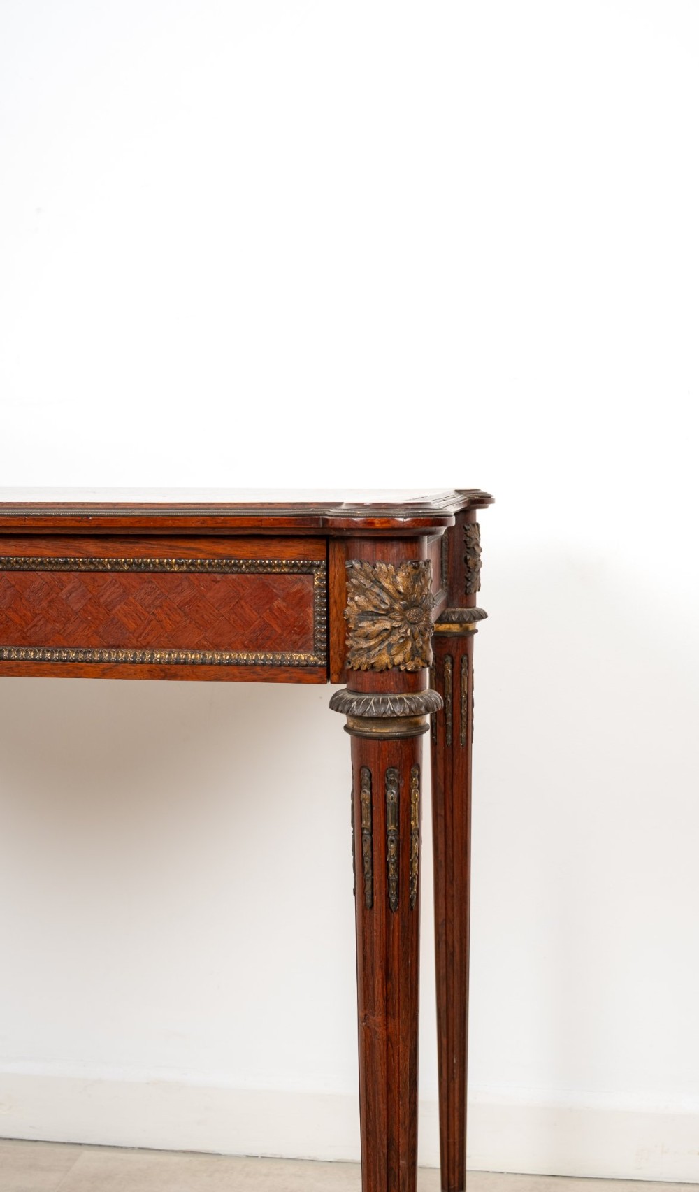 An antique French kingwood writing table featuring geometric parquetry, a single central drawer with ormolu mounts, and four tapered fluted legs. View VI