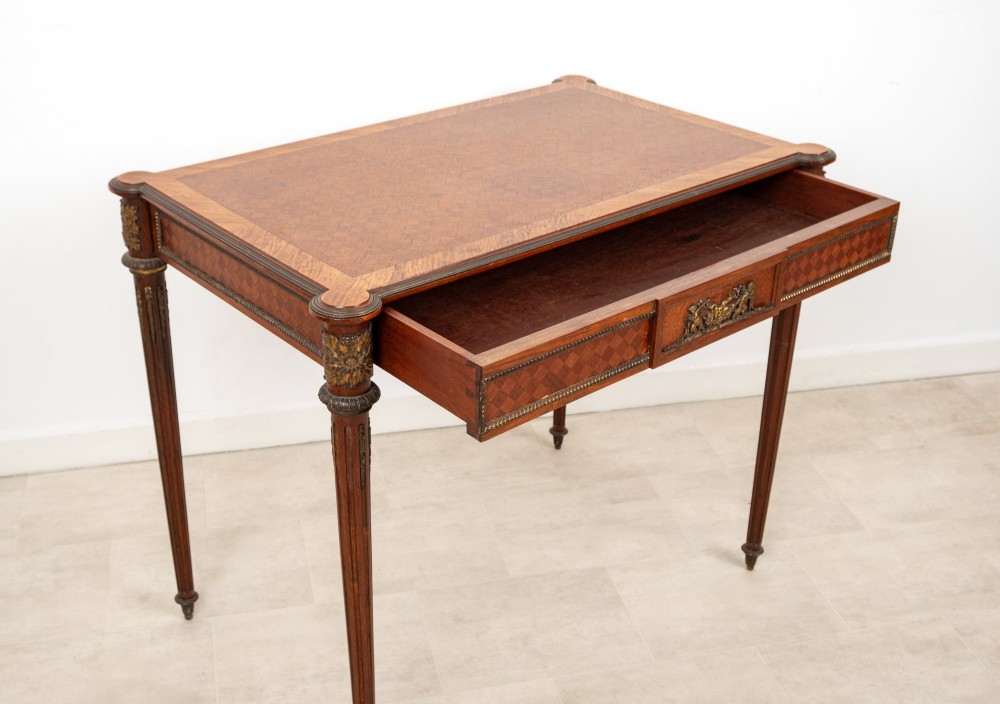 An antique French kingwood writing table featuring geometric parquetry, a single central drawer with ormolu mounts, and four tapered fluted legs. View VIII